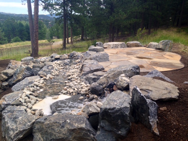 Stone water feature next to flagstone patio