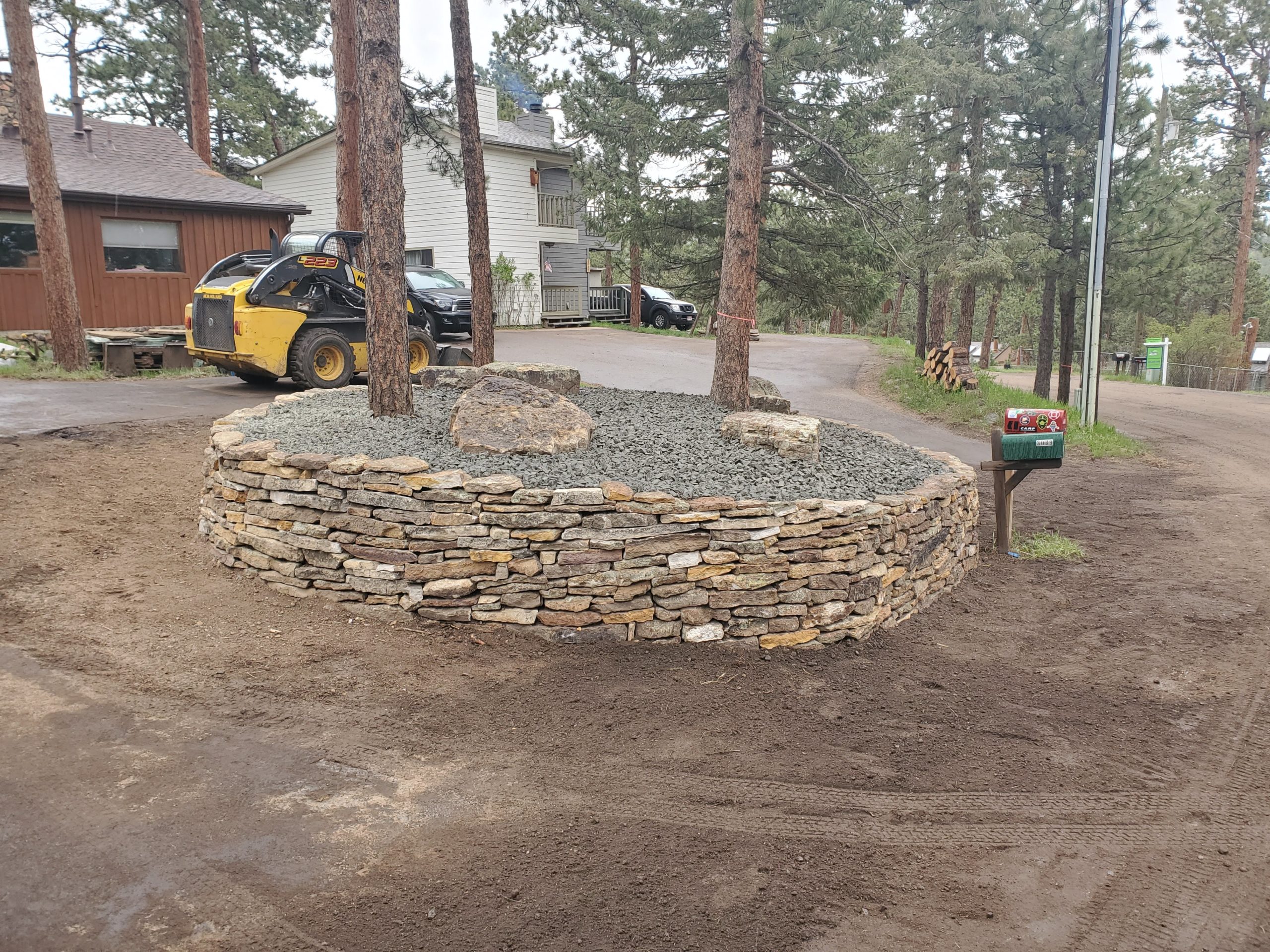 Circular retaining wall with three pine trees in the center.
