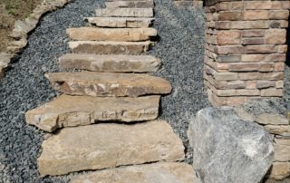 Natural stone staircase alongside house
