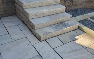 Short staircase leading to larger flagstone patio