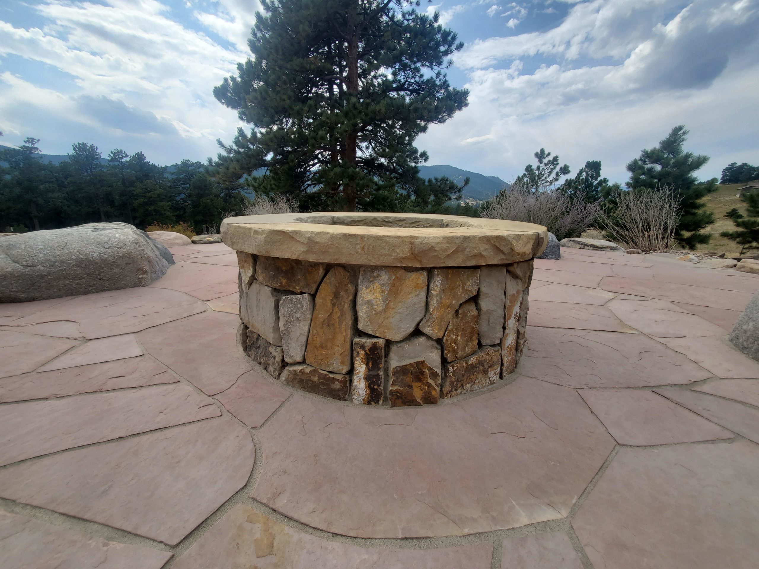 Close-up of stone fireplace with large river rock seating nearby