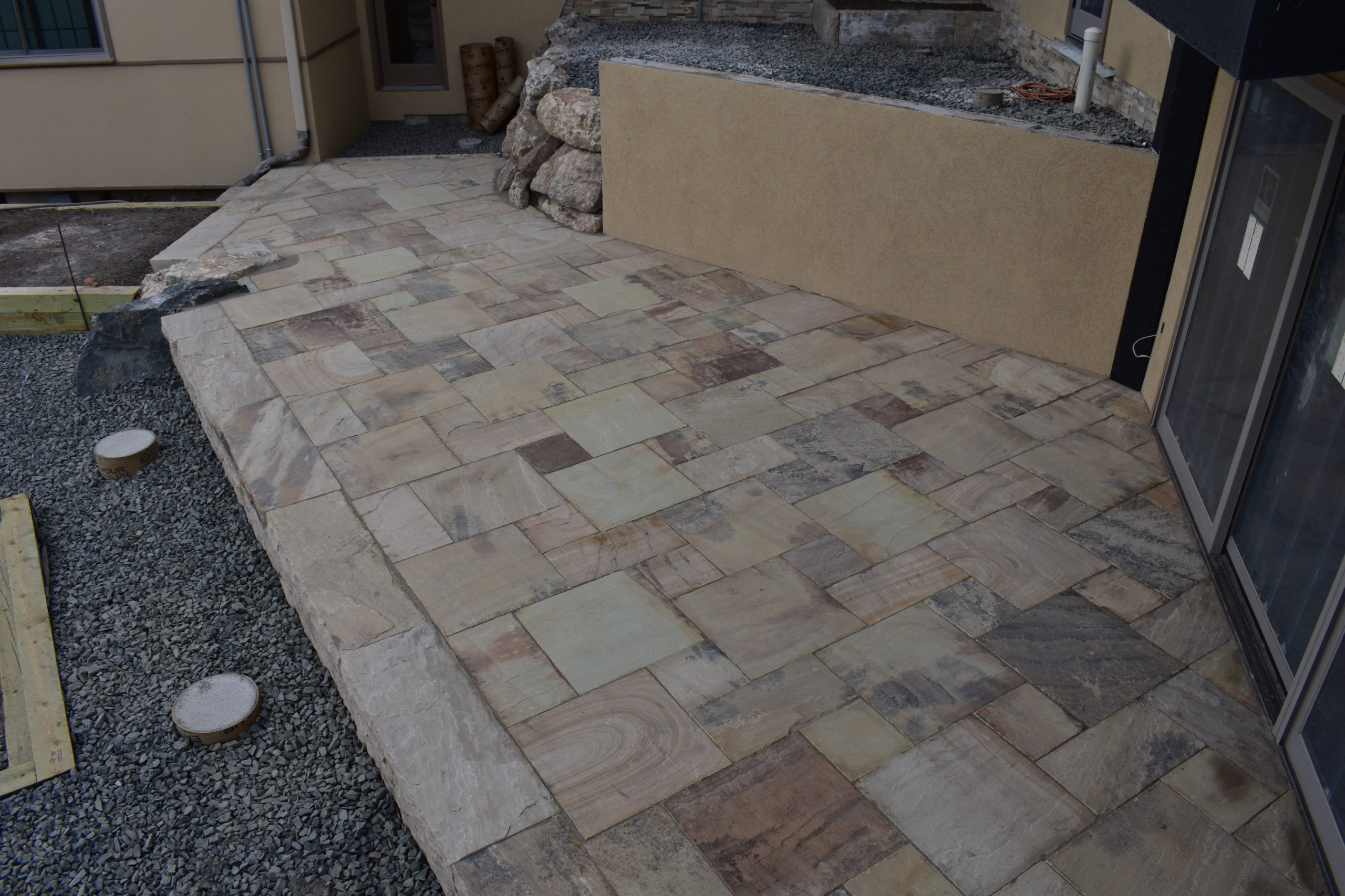 Square-shaped flagstone patio with retaining wall
