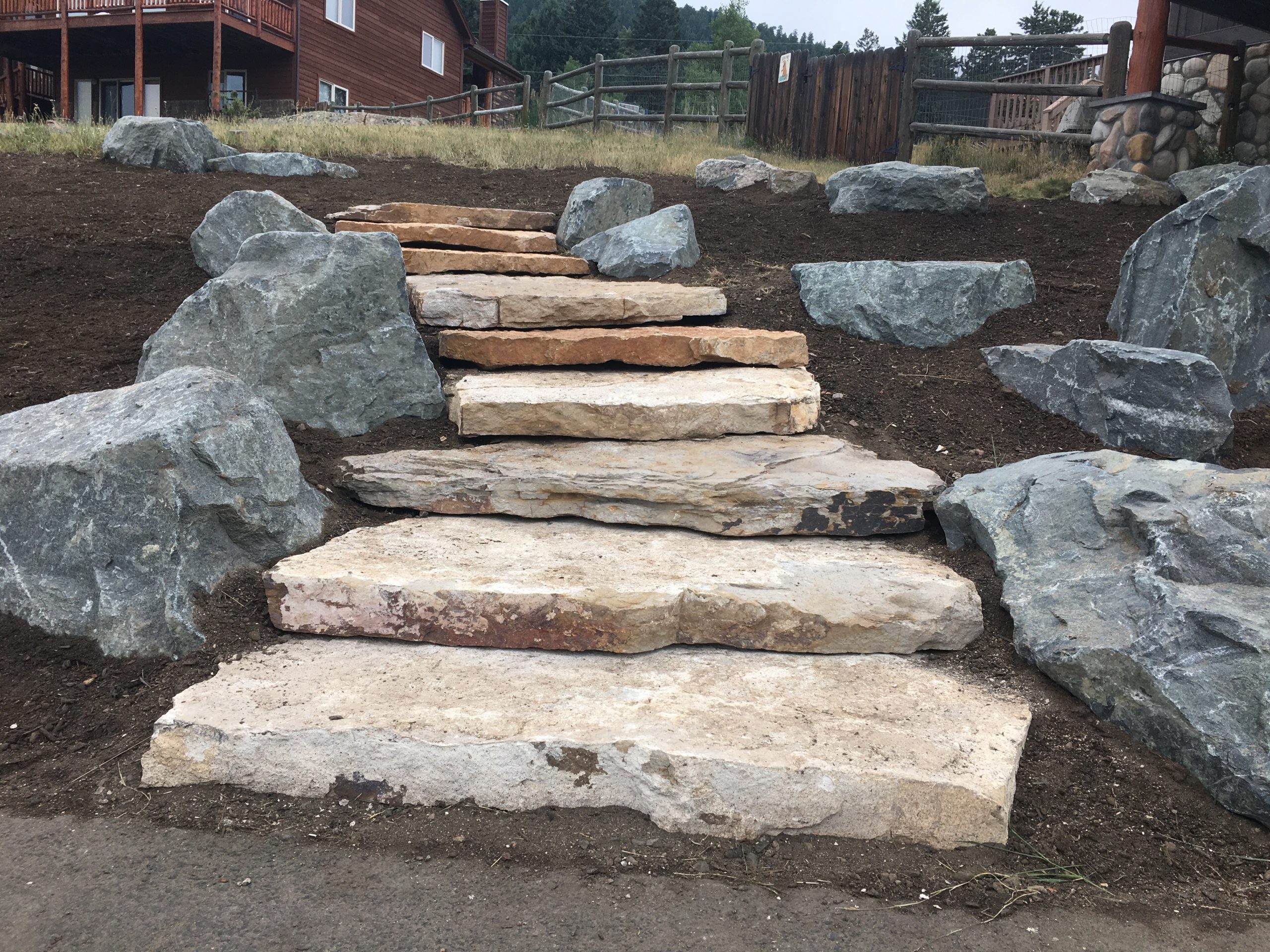 Wide flagstone staircase surrounded by boulders