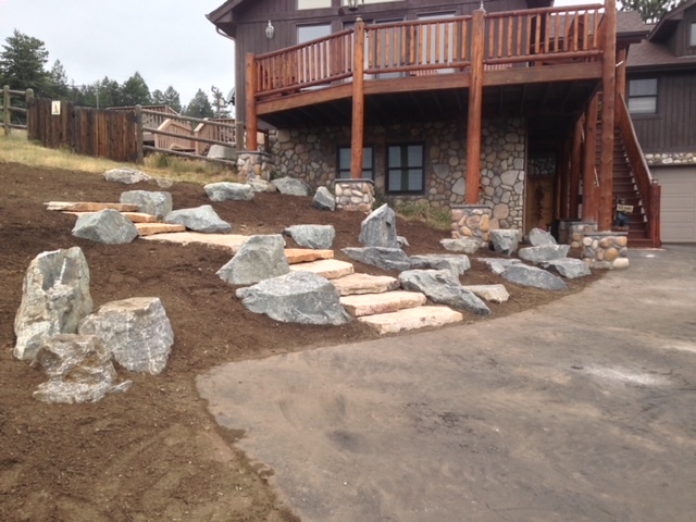 Stone staircase and boulders originating from parking area at house