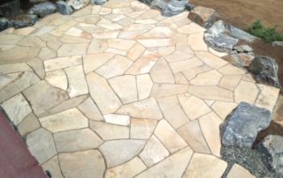 Light-colored stone patio surrounded by stones