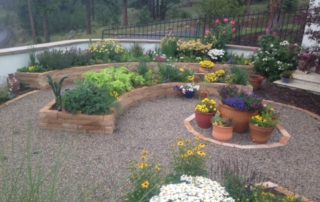 Concentric circles of garden beds surround flowerpots in center