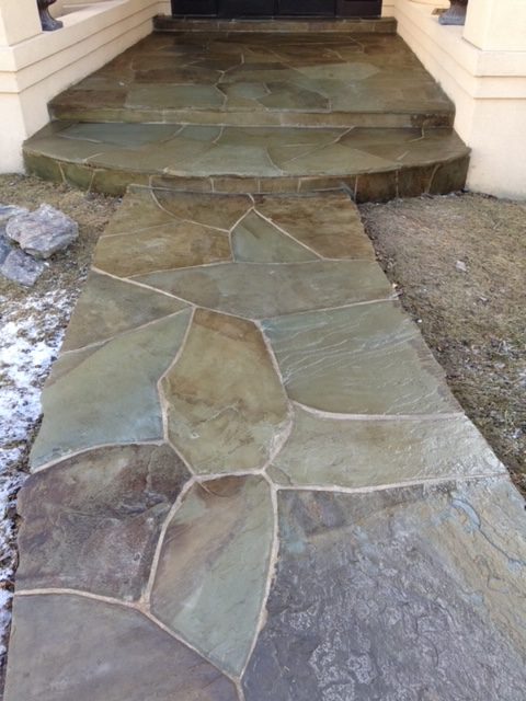 Greenish flagstone stairs and entryway to house