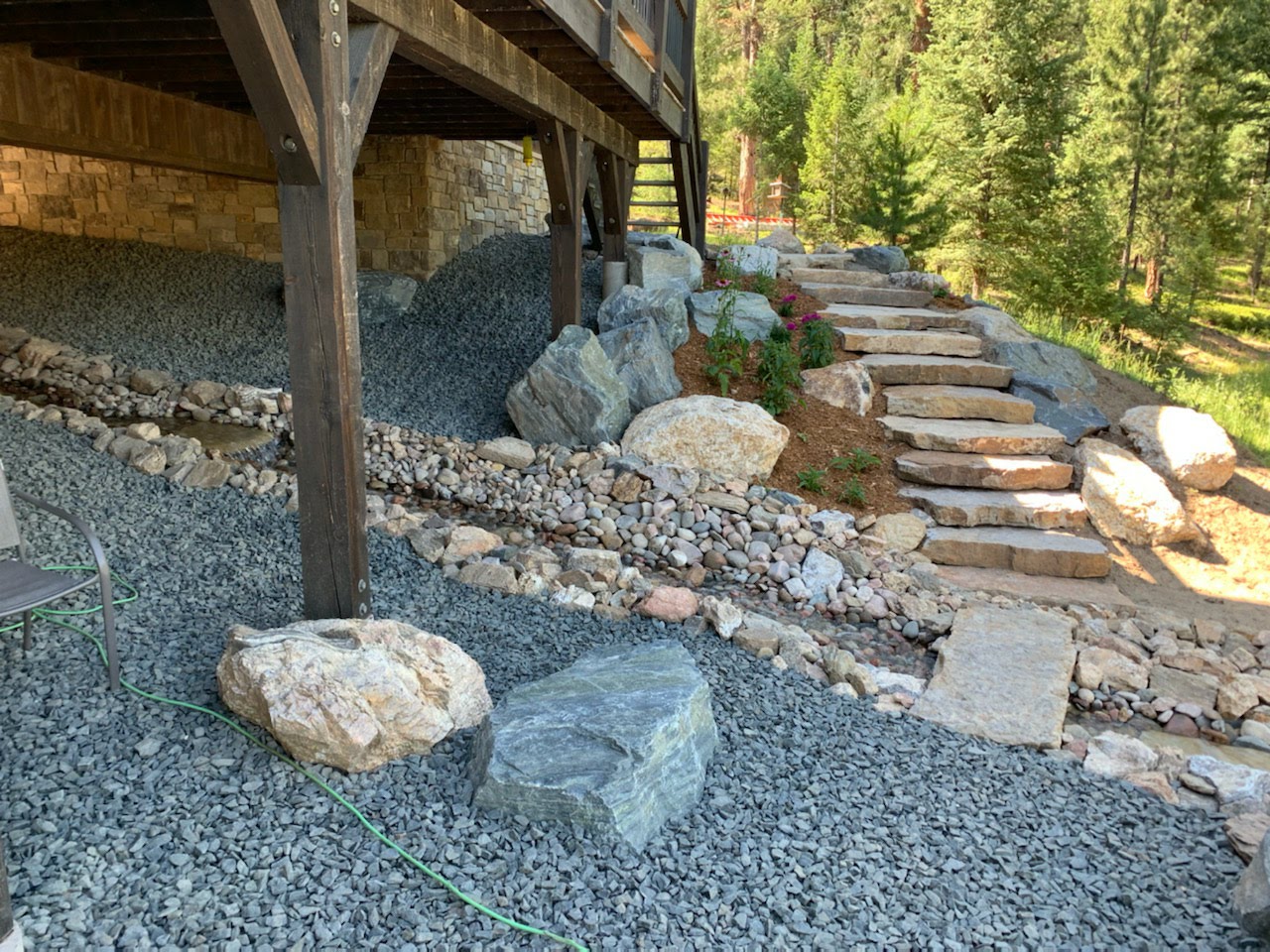 Landscaped streambed or water feature with rock staircase nearby