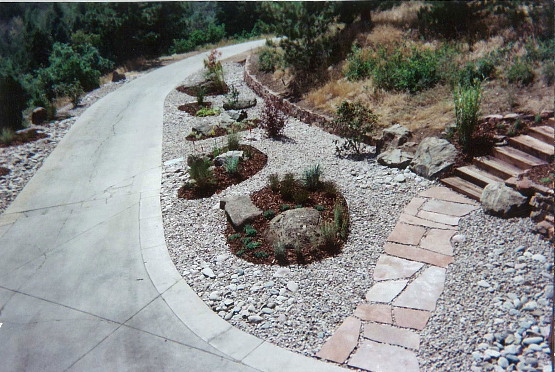 Small pockets of plants within stone landscaping
